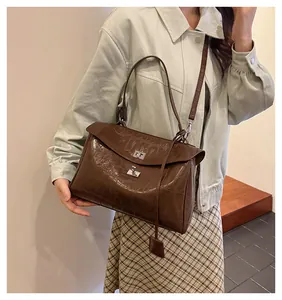 Close-up of brown crocodile pattern handbag featuring a silver-tone metal twist lock