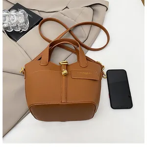 Vue détaillée du sac à main en cuir caramel avec serrure dorée et bandoulière réglable