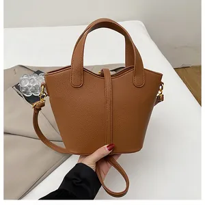 Détails d'un sac seau marron en cuir grainé avec d'élégantes finitions dorées