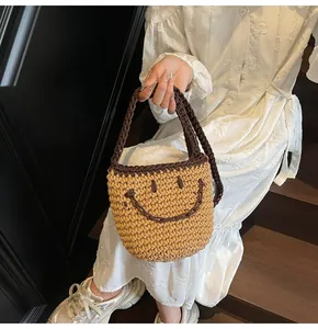 Detail of hand-woven bucket bag featuring a brown contrast smile design and handle