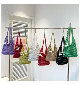 Detail of colorful hollow crochet tote bags with lily of the valley floral charms