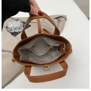 Vue intérieure d'un sac marron texturé avec doublure grise et poche à fermeture éclair