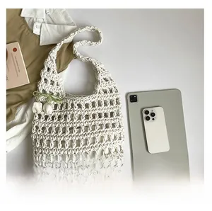 Detail of hollow woven tote bag with green ribbon and white tulip charm decoration