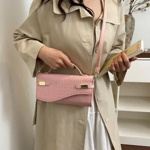 Pink woven texture crossbody bag with gold buckles and adjustable shoulder strap