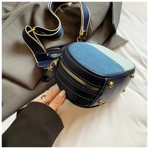 Detail der runden Denim-Umhängetasche mit farblich abgesetztem Patchwork und Nieten