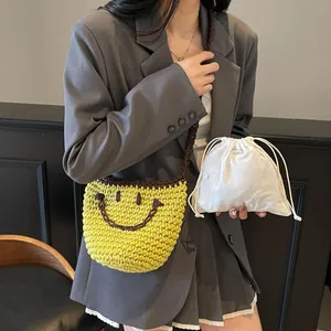 Yellow hand-woven bucket bag with a smiling face embroidery and white drawstring liner pouch