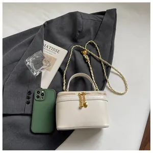 Detail of off-white box bag with gold metal chain and heart-shaped zipper charms