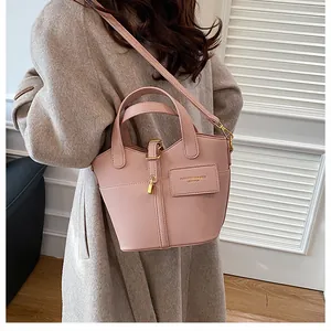 Détail du sac seau rose en cuir grainé avec poignée supérieure et bandoulière fine