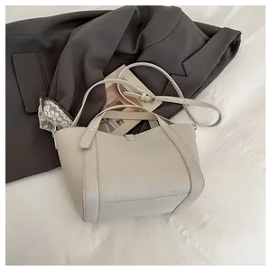Vue détaillée du sac cabas crème texture litchi avec bandoulière sur accessoires d'art