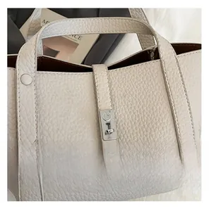 Détail de la texture cuir litchi et du fermoir en métal argenté du sac fourre-tout
