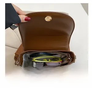 Internal view of brown saddle bag showing spacious compartment with magnetic clasp