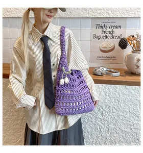 Detail of purple woven tote bag with white tulip pendants and openwork crochet texture
