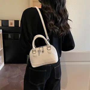 Sac à main en forme de coquillage crème avec breloque cœur et clé en intérieur