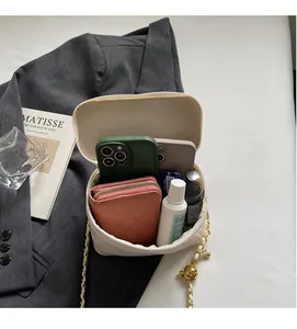 Detailed internal view of creamy white square bag showing capacity for phone and wallet