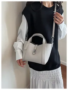 Détail du sac à main en cuir gris clair à grain de litchi avec finitions en métal argenté