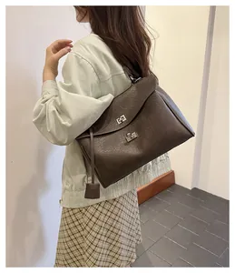 Vue détaillée du sac à main en cuir marron foncé avec fermoirs rotatifs en argent
