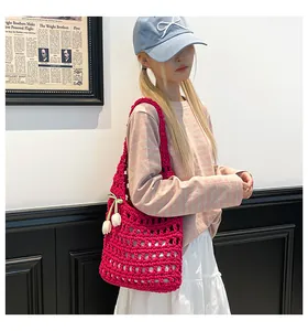 Detail of red hollow woven tote bag featuring a white tulip floral charm accessory
