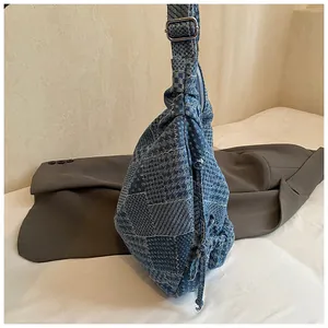 Detailed patchwork denim hobo bag featuring retro patterns and side drawstring texture