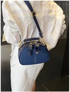 Nahaufnahme der Retro-Denim-Umhängetasche mit breitem Gurt und goldener Metallschnalle