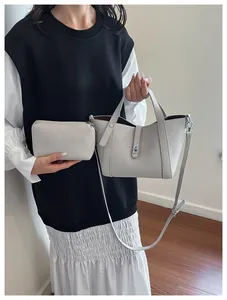Détail d'un sac seau en cuir grainé crème avec pochette et fermoir pivotant en métal