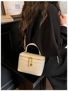 Creamy white leather crossbody bag with gold heart pendant and woven chain strap