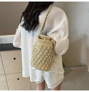 Detail of hand-woven beige straw bucket bag with textured crochet and drawstring lining