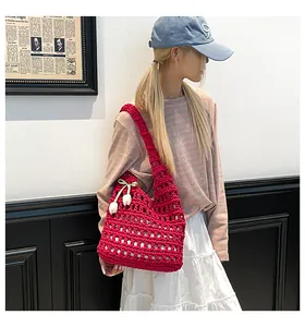 Detail of red hollow crochet tote bag with tulip charms and woven mesh texture