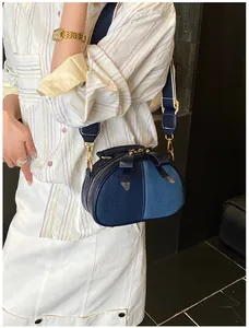 Detail der blauen Denim-Umhängetasche mit Lederschleife und breitem Schultergurt