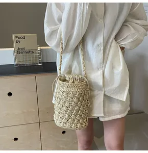 Detailed view of handmade beige woven bucket bag with intricate crochet pattern and drawstring