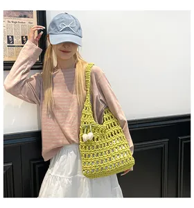 Close-up of lime green hollow knit tote bag with a white cherry pendant detail