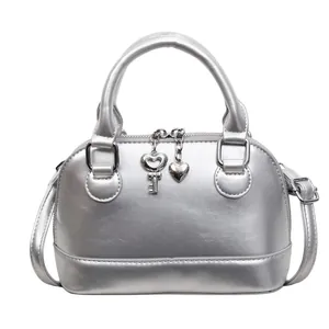 Fashionable silver shell-shaped crossbody bag with heart charm and metallic finish