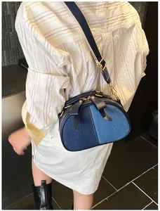 Detail der Denim-Umhängetasche mit Schleifen-Akzenten und breitem Gurt am Modell