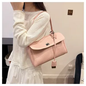 Gros plan du sac à main rose avec texture crocodile et fermoir rotatif argenté élégant