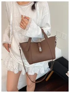 Détail du sac cabas en cuir litchi marron foncé avec fermoir rotatif et doubles poignées