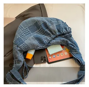Detail of spacious denim patchwork bag interior holding a tablet, phone, and cosmetics