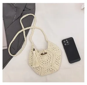 Détail du sac de plage au crochet crème avec bouton en bois et franges élégantes