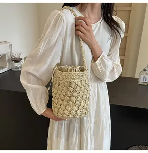 Detail view of woven bucket bag featuring 3D honeycomb crochet texture and drawstring closure