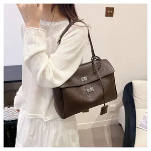 Détail du grand sac cabas marron foncé avec texture plissée et boucle métallique argentée