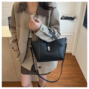Vue détaillée du sac à main noir en cuir litchi avec boucle métallique et bandoulière
