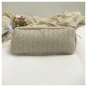 Détail du sac cabas en paille beige avec tissage en chevrons et base rectangulaire solide