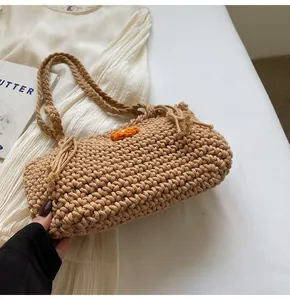 Detailed shot of beige crochet tote bag featuring orange floral knit patterns and rope straps