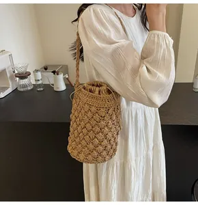 Detailed straw bucket bag featuring a secure drawstring lining and braided shoulder strap
