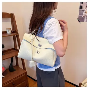 Détail du sac à main en cuir texturé crème avec fermoir rotatif argenté et étiquette