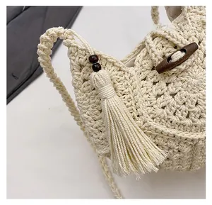 Détail du sac tissé crème avec boucle en corne de bois et pendentif à pompon décoratif