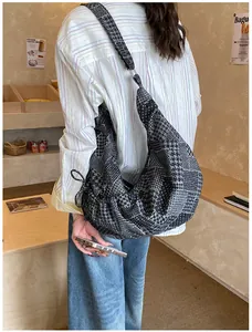 Detail of patchwork hobo bag with houndstooth pattern shown in a cozy cafe setting