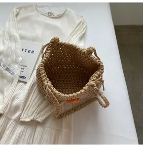 Close-up of woven straw tote bag with orange flower detail and braided handles