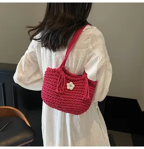 Detail of fuchsia hand-woven tote bag with 3D floral accent and fringe tassels