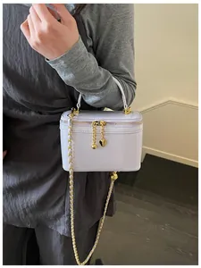 Detail of lavender vanity bag with gold heart charms and elegant chain shoulder strap