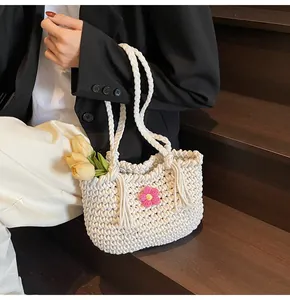 Detailed close-up of cream hand-woven tote bag with pink knit flower and tulip accent