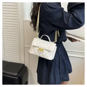 Détail du mini sac blanc matelassé avec fermoir doré et bandoulière sur un mannequin